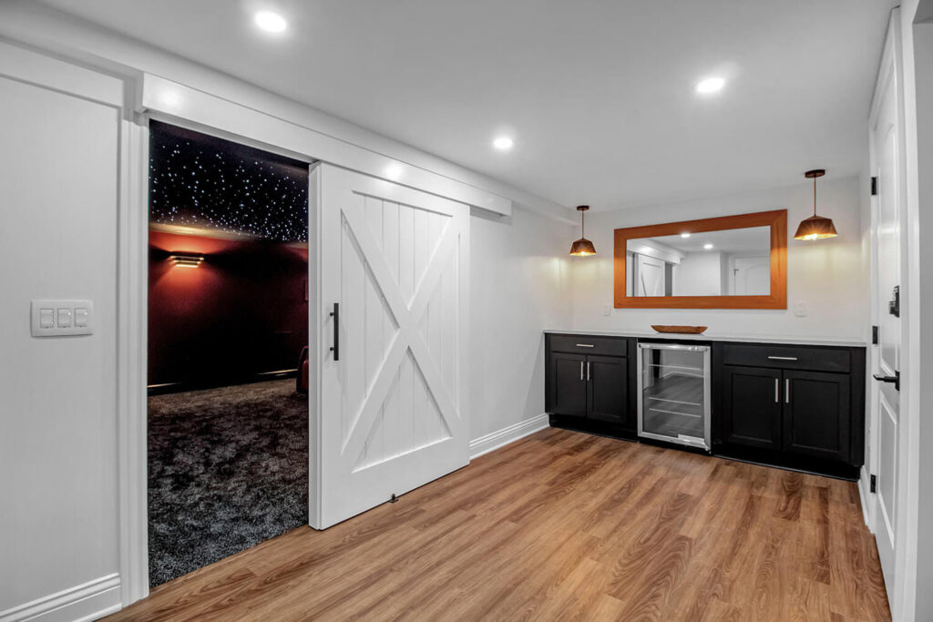 A home entertainment area featuring a barn door leading to a theater and a wet bar, constructed by Bob Build's WNY in Buffalo, NY.