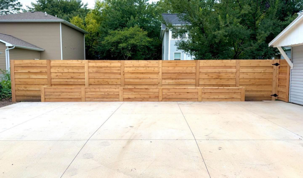 A modern horizontal slat wood fence with integrated planter boxes, installed by Bergmann Fencing Co. in Cedar Falls, IA.