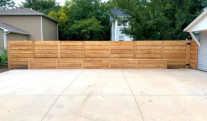 A modern horizontal slat wood fence with integrated planter boxes, installed by Bergmann Fencing Co. in Cedar Falls, IA.
