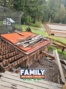 A dismantled hot tub and wood debris in a backyard, showing a removal job by Family Junk Removal and Hauling LLC in Seattle, WA.
