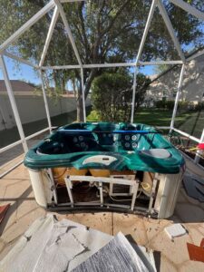 A hot tub being dismantled inside a screened enclosure, showing the in-progress junk removal service by Route Junk in Orlando, FL.