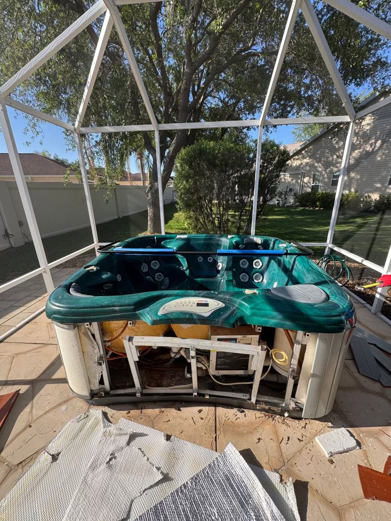 A hot tub being dismantled inside a screened enclosure, showing the in-progress junk removal service by Route Junk in Orlando, FL.