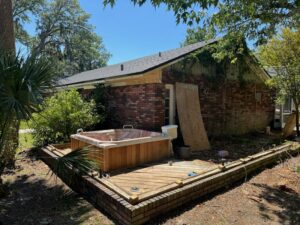 A hot tub situated on a wooden deck in a backyard, ready for professional removal by Route Junk in Orlando, FL.