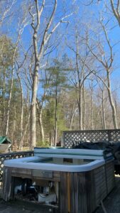 A hot tub on a deck, partially disassembled, indicating a removal job by O'Brien Property Services in Clay, NY.