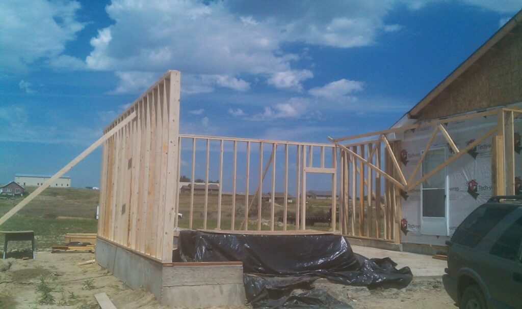 A house under construction with new wooden framing for an addition, a project by The Creative Carpenter in Minot, ND.