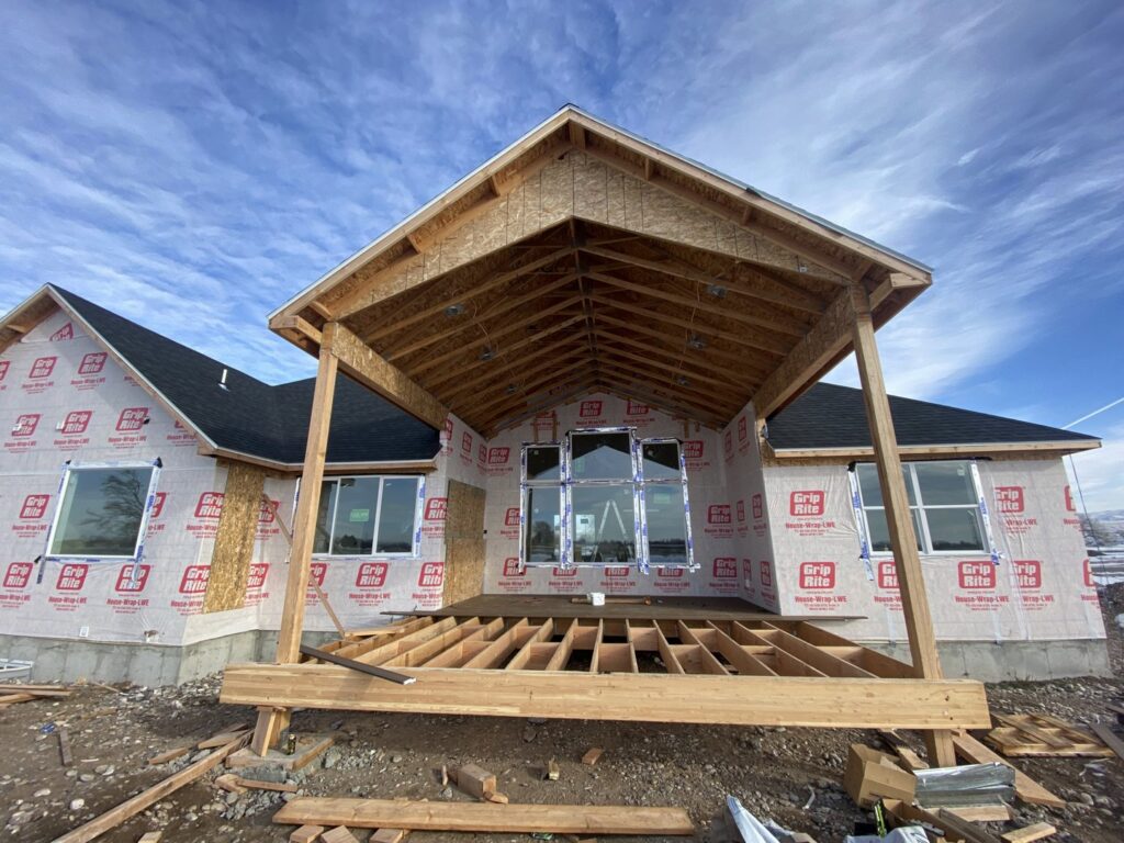 A new house under construction with extensive deck framing, demonstrating building services by No Delay SVCS in Pocatello, ID.
