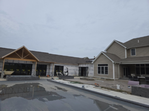 A large house undergoing construction with roofing work and a pool area by Rock Solid Const in Youngstown, OH.