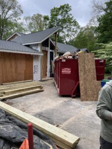 House construction site with a large red dumpster for debris removal by LCM FRAMING LLC in Danbury, CT