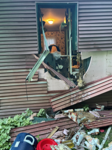 Debris from a damaged house, including broken siding and trash, requiring cleanup by Greater Upper Valley Solid Waste Management District in Ascutney, VT.