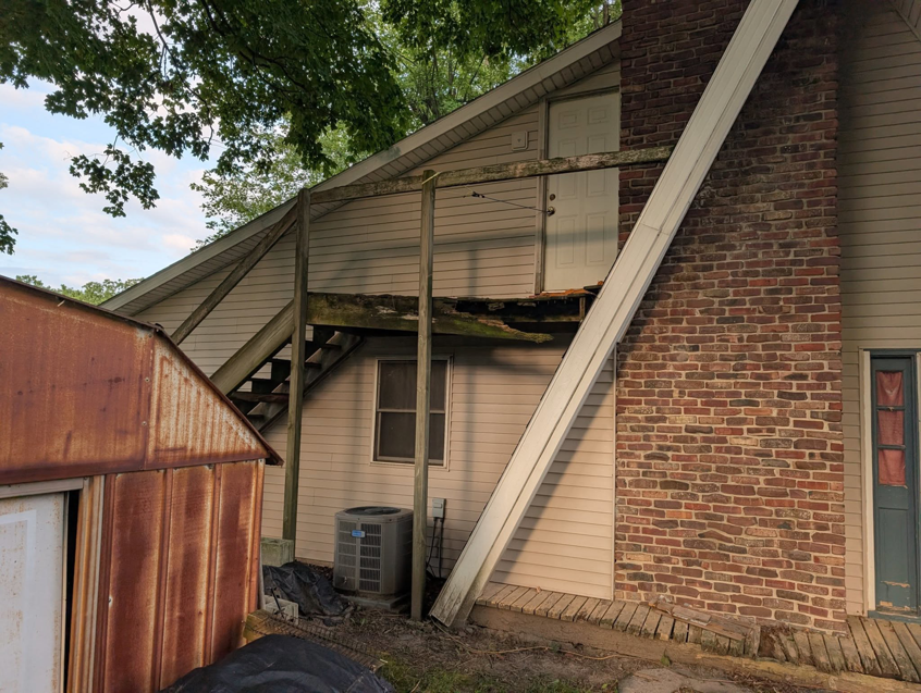 The exterior of a house showing a partially damaged deck structure, ready for repair by Handyman Service in Lafayette, IN.