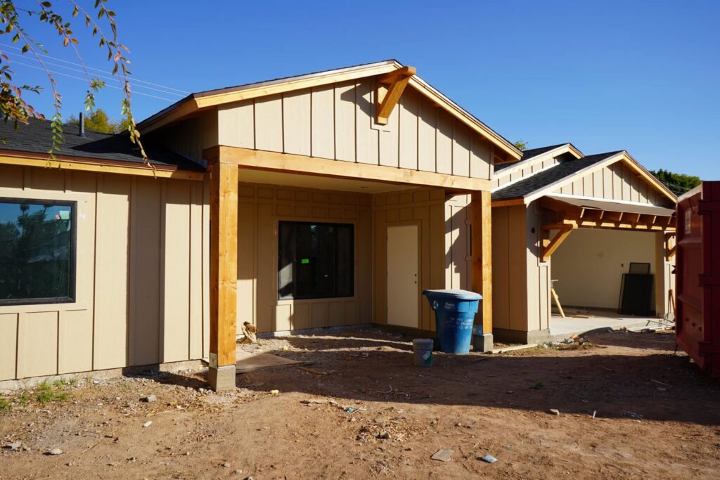 An exterior view of a house under construction, showing framing and siding installation by Kelso Custom Builders, Inc. in Phoenix, AZ.