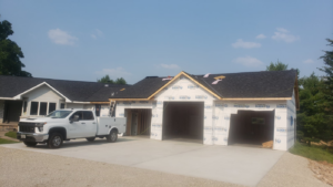 The exterior of a house with a garage addition under construction, handled by Ironside Home Improvements, LLC in Madison, WI.