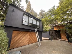 House exterior with a ladder and a freshly painted garage door by J&R Buezo Painting Services LLC in Everett, WA