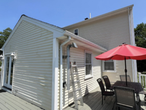 The exterior of a house with a ladder, indicating gutter cleaning or repair by Corriveau Home Improvement LLC in Bristol, CT.