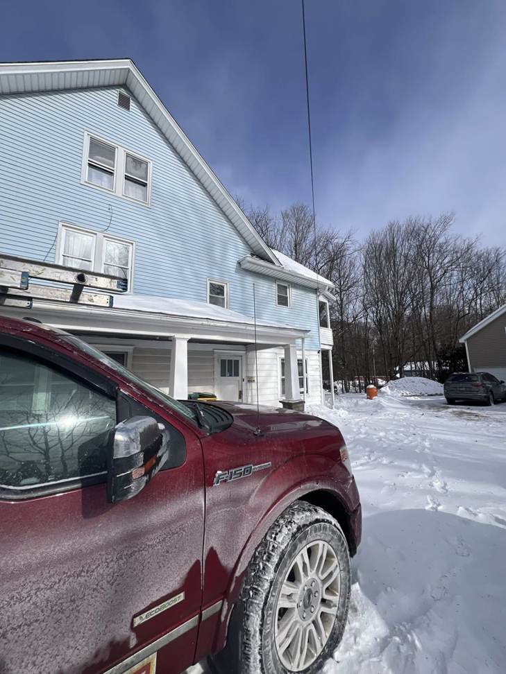 A house exterior with a ladder leaning against it and a work truck, indicating a general contractor job by Manny General Construction Llc in Scranton, PA.