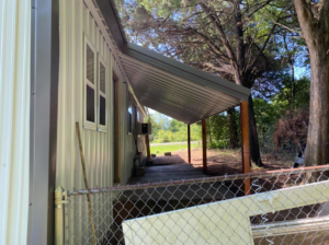 A house exterior with new metal siding and a metal porch cover installed by Sterling Renovations in Grapevine, TX.