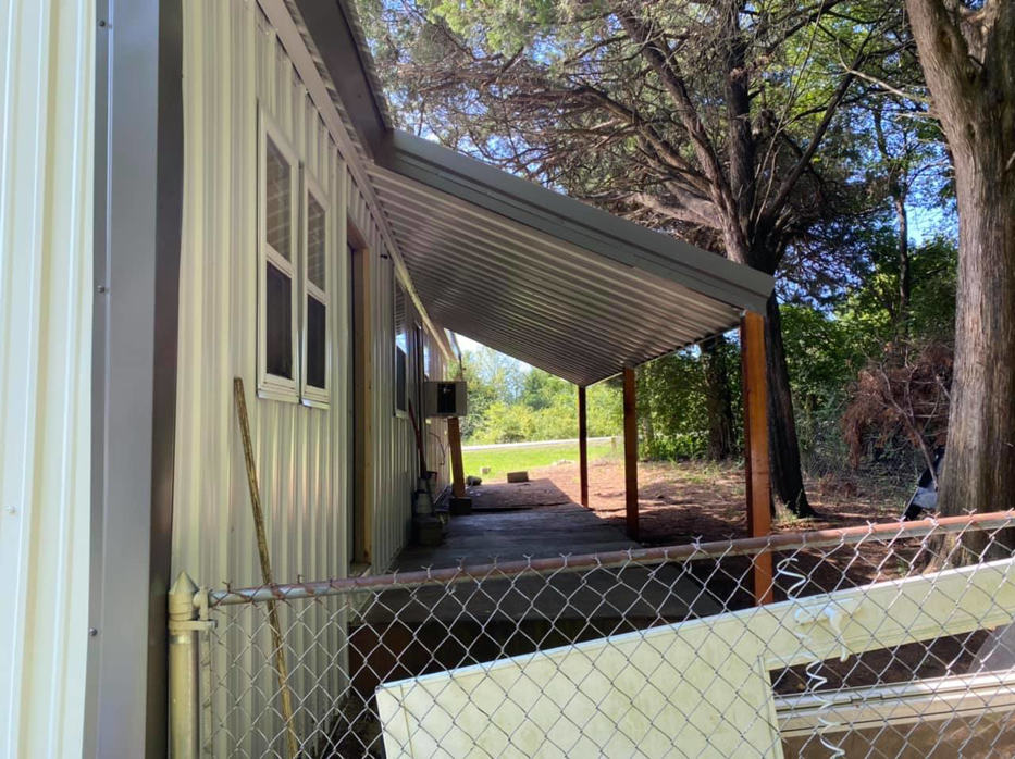 A house exterior with new metal siding and a metal porch cover installed by Sterling Renovations in Grapevine, TX.