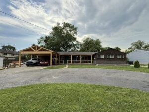 The exterior of a house featuring a newly constructed wooden carport and porch by Enjaycee Unlimited in Cincinnati, OH.