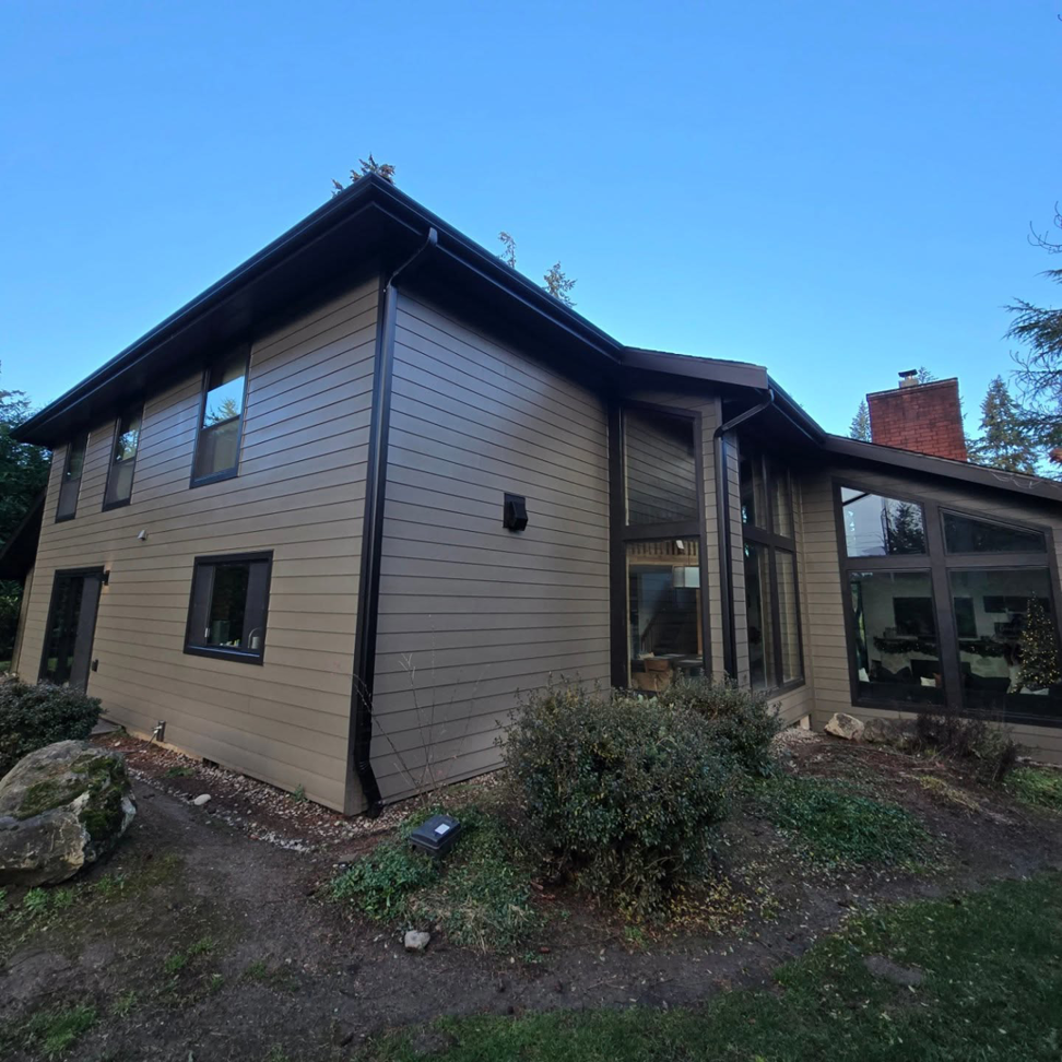 The renovated exterior of a house featuring new siding and gutters by Final Touch Construction, LLC in Tukwila, WA.