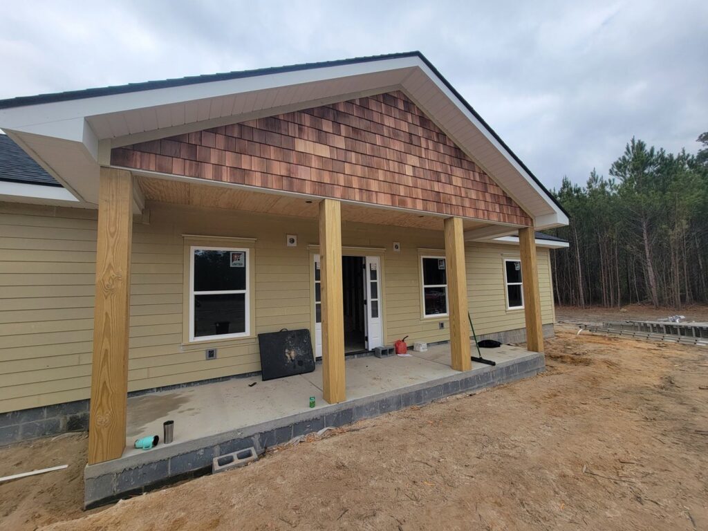 House exterior with new tan siding and wooden porch posts by American Custom Exteriors in North Charleston, SC.