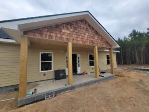 House exterior with new tan siding and wooden porch posts by American Custom Exteriors in North Charleston, SC.