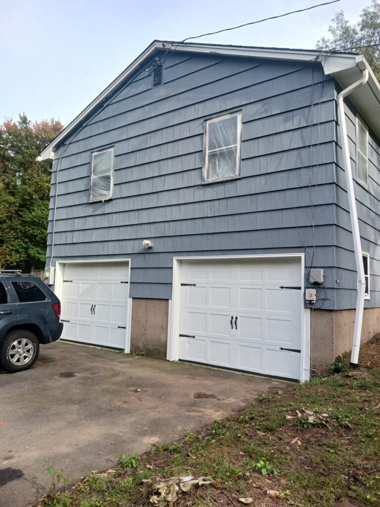 Exterior of a house with windows covered for painting preparation by SID Painting in West Hartford, CT.