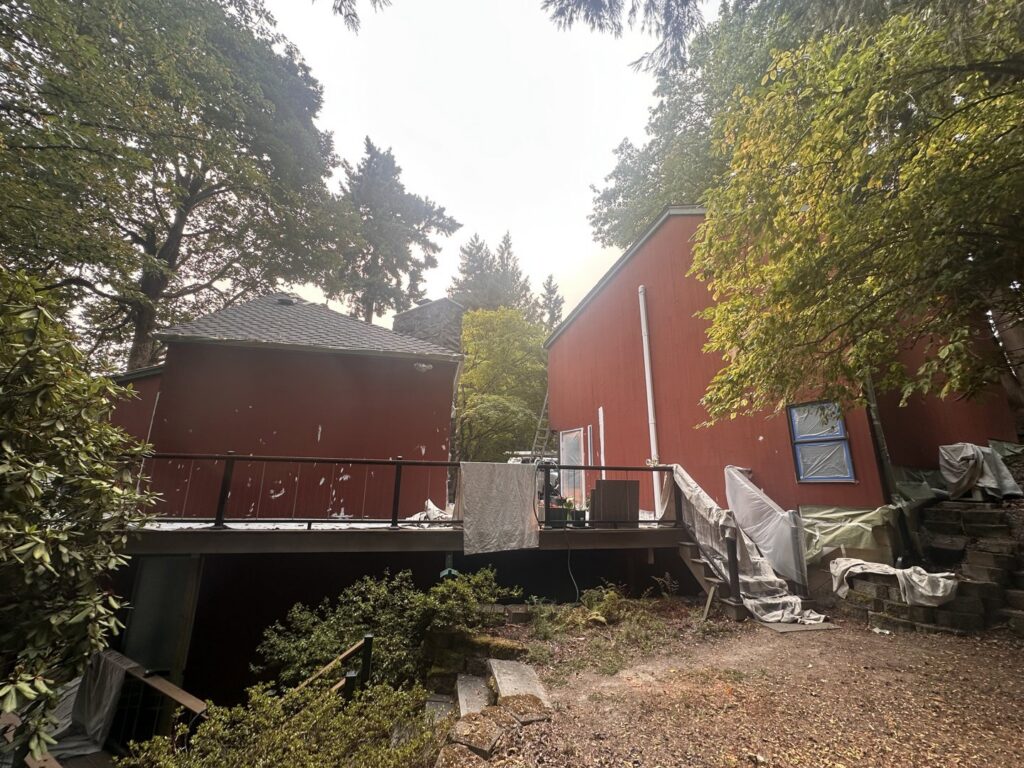 House exterior painting preparation with protective tarps and taped windows by J&R Buezo Painting Services LLC in Everett, WA