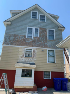 A house exterior with peeling paint, indicating an ongoing repainting project by D'Costa Finish Painting in Fall River, MA.