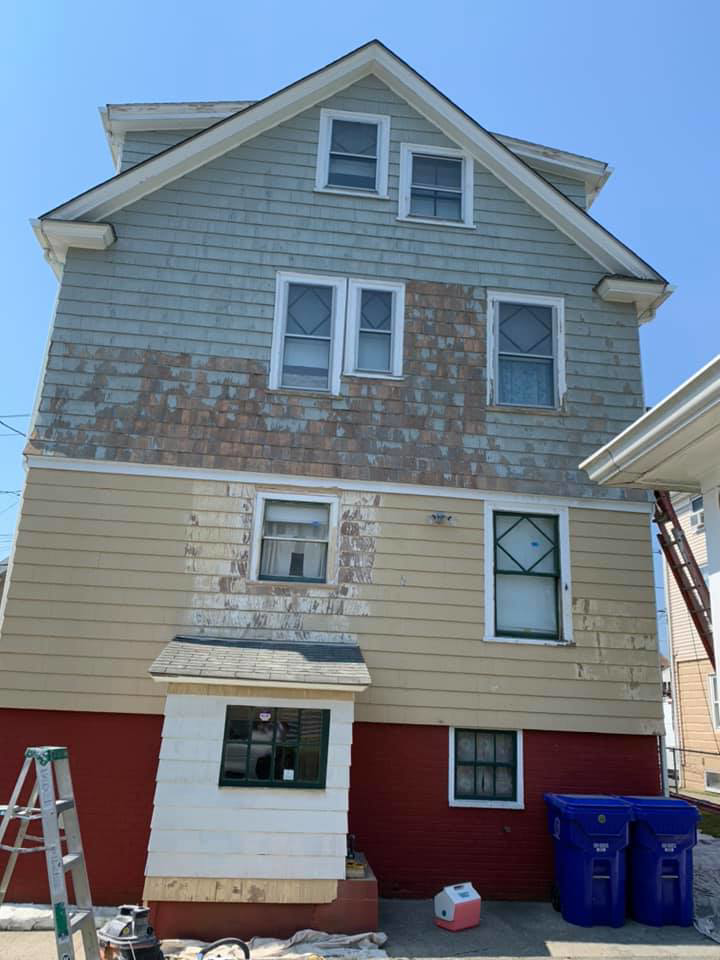 A house exterior with peeling paint, indicating an ongoing repainting project by D'Costa Finish Painting in Fall River, MA.