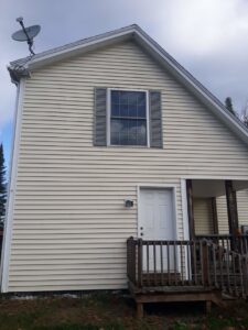 The exterior of a house with a porch, showing an area for potential handyman services by Phoenix's Cleaning Service, LLC in Rutland, VT.