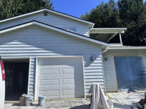 House exterior prepped for painting with buckets and protective tarps by J&R Buezo Painting Services LLC in Everett, WA