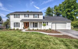 A beautifully renovated house exterior with white siding and black shutters, completed by Pluff Contractors LLC in Lancaster, PA.