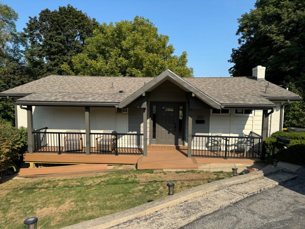 A beautifully renovated house exterior featuring a new porch, deck, and updated siding by Gold-Mine Construction, LLC in Pittsburgh, PA.