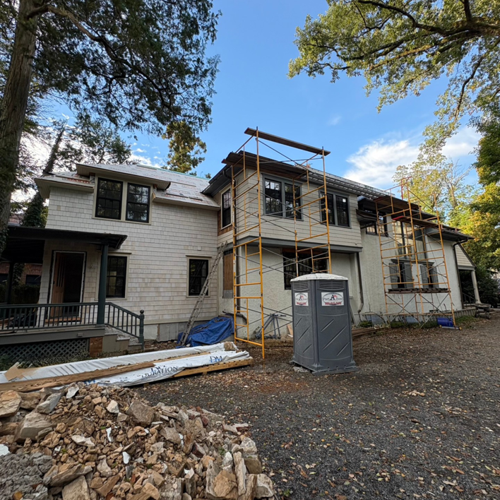 Large house exterior renovation with scaffolding and construction debris by Alloway Construction & Restoration Inc in Skillman, NJ