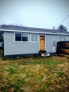 House exterior undergoing renovation with new siding and boarded door by Investment Handyman Services in Pocatello, ID