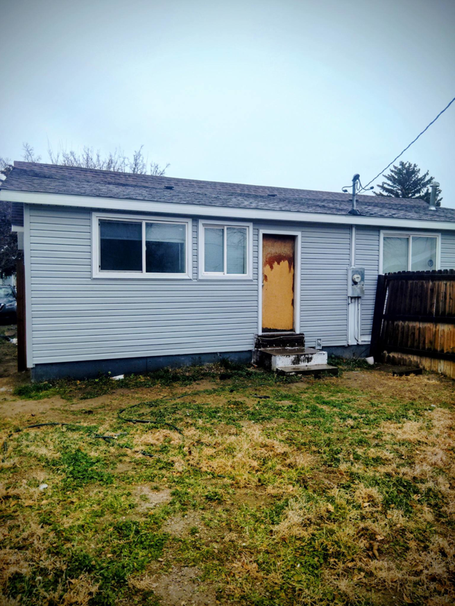 House exterior undergoing renovation with new siding and boarded door by Investment Handyman Services in Pocatello, ID