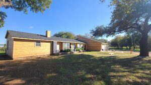A house undergoing a full exterior renovation with new siding and roof by Finesse Painting and Remodeling in Fort Worth, TX.