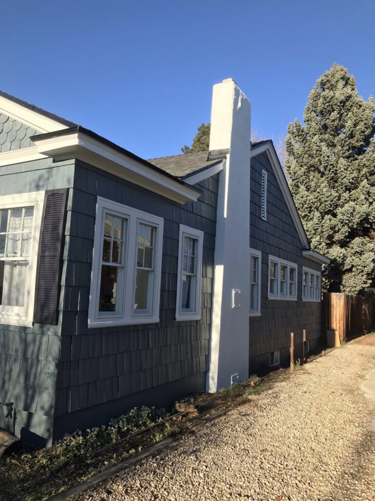 Exterior of a house with new shingle siding and a freshly painted chimney, completed by FES handyman services LLC in Boise, ID.