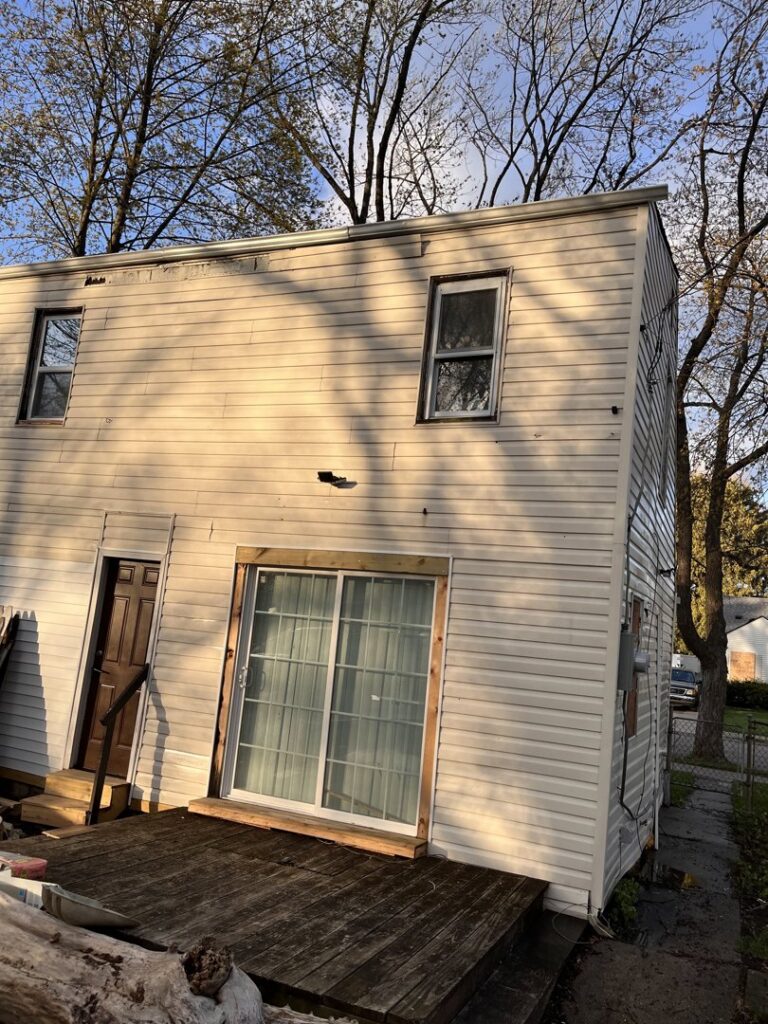 House exterior with dirty siding and a deck, showing potential work for Applied Pressure LLC in Detroit, MI.