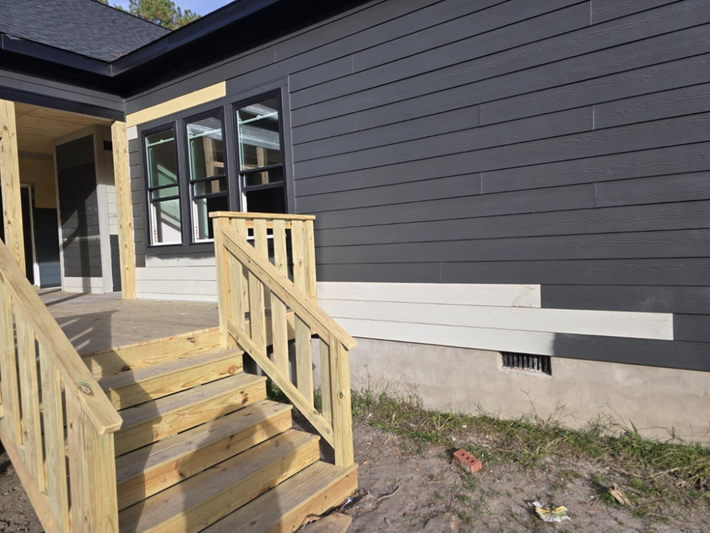 Exterior view of a house with new siding and a wooden porch with railings by MAF Construction LLC in Raleigh, NC
