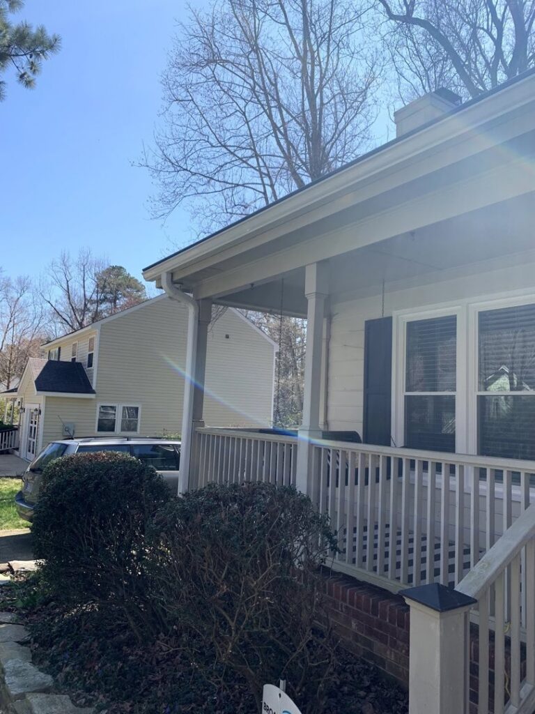 The exterior of a house with light-colored siding and a welcoming porch, serviced by NC Siding and Windows in Raleigh, NC