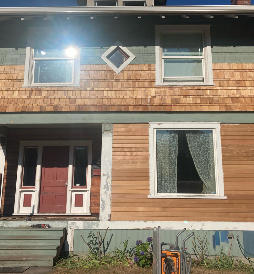 A house undergoing exterior siding renovation with old siding removed by Nation / Phillips Construction in Tacoma, WA.