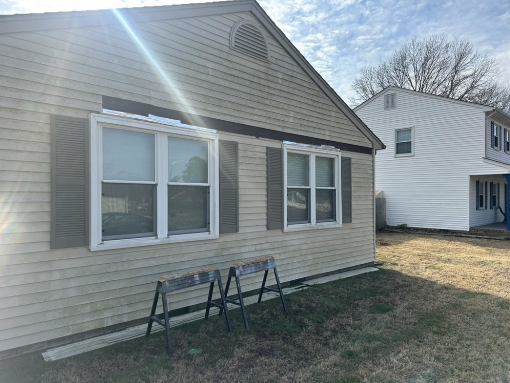 Side of a house showing exterior siding and window repair in progress by Jps handyman services,inc in Hampton, VA.