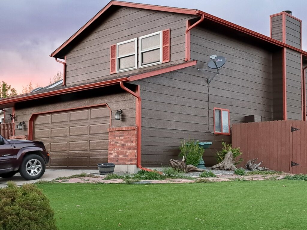 A house exterior with two garages and stone accents, showcasing work by Greg Unseth Painting & Exteriors in Colorado Springs, CO