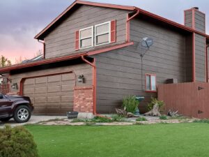 A house exterior with two garages and stone accents, showcasing work by Greg Unseth Painting & Exteriors in Colorado Springs, CO