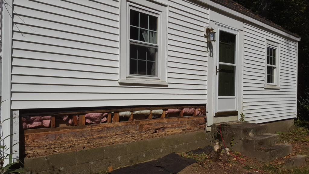 Exterior view of a house showing damaged lower wall section requiring repair by DiBenedetto Building & Remodeling in Worcester, MA.