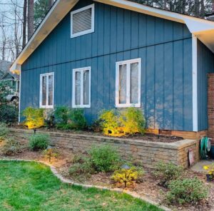 A house exterior with newly painted blue siding and updated landscaping lights by Prime Painting in Charlotte, NC.