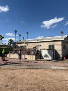 The exterior of a house with a CzechList Junk Removal dumpster visible on a job site in Scottsdale, AZ.