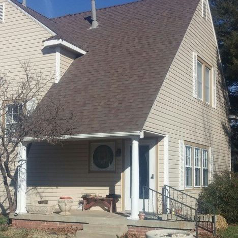 A house exterior featuring siding and a new roof, showcasing work by Hurst Siding Co. in Norman, OK