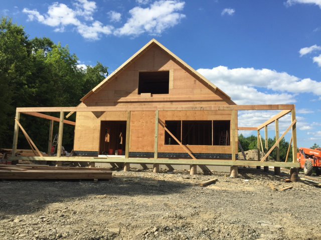 A house under construction with wood framing and a large deck being built by Carl Gardner Contracting in Syracuse, NY.